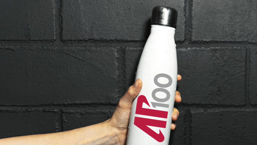 Hand holding a white water bottle with the AP 100 logo.